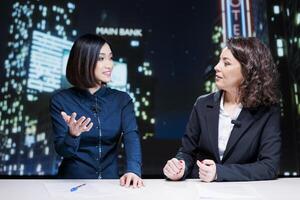 Presenters team host night talk show in newsroom, reporting important topics information with exclusive details. Diverse journalists reporting celebrity drama and creating tv content. photo