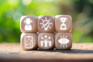 Wooden blocks with success icons representing achievement, innovation, and teamwork in a natural setting. photo