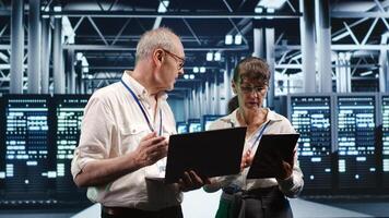 Tech support consultants monitoring energy efficient data center infrastructure. Server parts using renewable sources employed to minimize consumption and reduce overall location carbon footprint photo