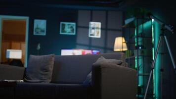 Contemporary studio with modern decorations and neon lights creating a cozy casual living space with a smart tv and comfortable setup. Empty apartment loft with trendy furniture. video