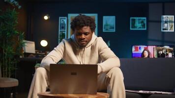 focado homem acionado dentro conectados pesquisa para uma trabalhos projeto às lar, sentado às dele café mesa com computador portátil e lendo artigos em a Internet. pessoa surfar paginas web e encontro dados. Câmera b. video
