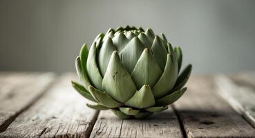 A single artichoke on a textured wooden table photo