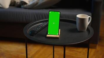 noir Masculin éloigné ouvrier pose sur le canapé suivant à chrominance clé afficher, profiter loisir et gratuit temps pour relaxation dans le sien moderne grenier appartement avec néon lumières et une intelligent la télé. caméra un. video