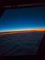 Cockpit view at sunrise. horizon, soft clouds, crescent moon frame the window. High quality photo