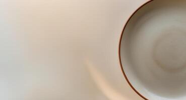 a close up of a plate with a brown rim on a beige background photo