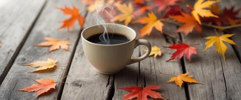 Black coffee in a ceramic cup surrounded by autumn leaves on a wooden table photo