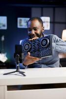 Artist filming DJ mixing tutorial in recording studio, pressing different buttons to show device capabilities. Music production guru showcasing audio equipment to audience on niche online channel photo