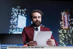 Media host announces new supermoon appearing on sky, creating entertainment content for midnight show. Man journalist on live program talking about magical astronomy event. photo