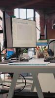 Vertical Empty AI tech agency workspace providing custom software development services. Machine learning technology running on PC in startup office to streamline coding process, jib up shot video