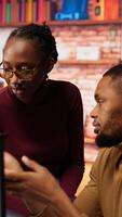 Vertical Teamworking programmers creating deep learning models analyzing data in artificial intelligence development agency. African american IT coworkers programming in AI startup office, camera B video