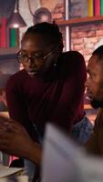 Vertical Team of startup workers conducting code review on PC to fix bugs, identifying technical issues with artificial intelligence company software. IT staff members optimizing code using device, camera B video