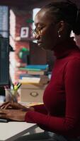 Vertical IT startup worker using large language model application to get help with coding tasks. Woman interacting with AI LLM chatbot PC GPT software on PC in software development workplace, camera A video