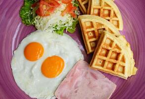 Eggs with ham and salad and belgian waffles close up. photo