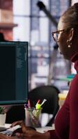 Vertical IT technician in startup office using large language model to get help with coding project. IT specialist interacting with AI LLM chatbot on PC in software development business company, camera B video