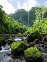 Lush green landscape with waterfall cascading down a mountainside photo