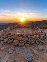 Sunset over mountain range viewed from stone circle photo