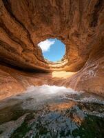 Waterfall cascading into a natural pool inside a cave photo