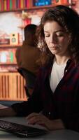 Vertical Portrait of upbeat programmer coding advanced AI algorithm in startup, refining machine learning models to enhance automation. Cheerful woman using coding platform in Silicon Valley office, camera A video