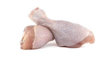 Two raw chicken drumsticks resting on a white background photo