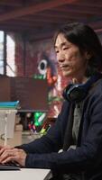 Vertical AI startup senior programmer overseeing deep learning application, thinking how to improve software. Asian artificial intelligence tech venture engineer using PC to fix code bugs, camera A video