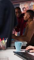 Vertical Team of startup workers conducting code review on PC to fix bugs, identifying technical issues with artificial intelligence company software. IT staff members optimizing code using device, camera A video