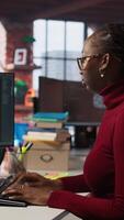 Vertical IT technician in startup office using large language model to get help with coding project. IT specialist interacting with AI LLM chatbot on PC in software development business company, camera A video