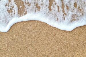 A wave on the sand with white foam photo
