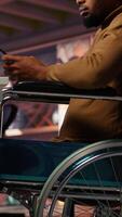 Vertical Engineer with disability coding AI algorithms in inclusive startup office using tablet, refining machine learning models. Man in wheelchair coding on device in Silicon Valley workplace, camera B video