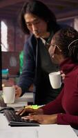 Vertical Tired admin in AI startup office having strained eyesight from overworking, getting help from senior manger. Woman removing eyeglasses to rub eyes, encouraged by team leader to take break, camera B video
