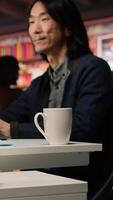 Vertical Senior engineer coding advanced AI algorithm in startup office, refining machine learning models to enhance automation. Asian CTO manager using coding platform in Silicon Valley workplace, camera A video