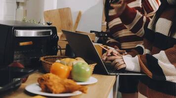 A woman using a laptop while standing in front of a microwave video