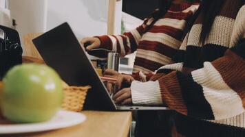 Two people using a laptop in a kitchen video