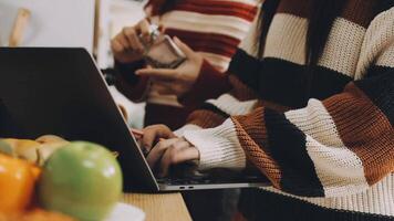 Two people using a laptop in front of a table with fruit video