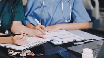 Two doctors are writing on a clipboard video