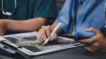 Two doctors are using their phones while sitting at a table video