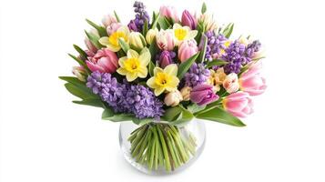 Vibrant spring bouquet with tulips and daffodils in glass vase on white background photo