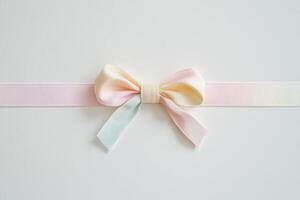 Pastel gradient ribbon bow on white background for gift decoration and craft projects photo