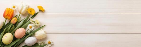 Easter eggs and spring flowers arrangement on wooden background with copy space photo