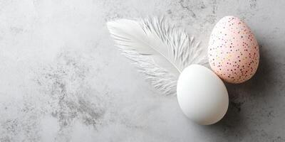 Two decorative eggs with feather on textured background for easter holiday theme photo