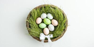 Colorful easter eggs arranged in a nest of green grass with a white bow photo