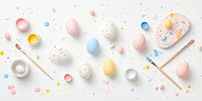 Pastel easter egg decoration with paint splatters and brushes on white background photo