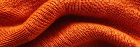 Close-up of orange knitted fabric texture featuring intricate patterns photo