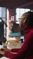 Vertical Exhausted AI startup employee rubbing forehead while analyzing datasets on computer, receiving coffee from project CTO manager to get energy and continue coding, camera A video