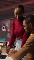 Vertical Teamworking startup engineers writing message on sticky notes while coding advanced AI algorithm. Coworkers in artificial intelligence Silicon Valley workspace leaving memo on PC screen, camera A video