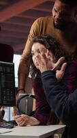 Vertical Startup team in office disappointed after watching stock exchange valuation decline because of market volatility. Upset venture workers analyzing charts, seeing stock valuation drop, camera A video