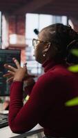 Vertical Tired admin in AI startup office having strained eyesight from overworking, getting help from senior manger. Woman removing eyeglasses to rub eyes, encouraged by team leader to take break, camera A video