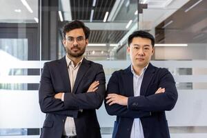 Two business professionals stand confidently with arms crossed in modern office, highlighting concepts of leadership, determination, and teamwork. Ideal representation of corporate atmosphere photo