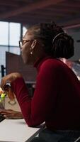 Vertical AI startup engineer eating snack while waiting code to finish compiling, annoyed by long wait. Irked software development agency employee consuming food, exasperated by sluggish PC, camera A video