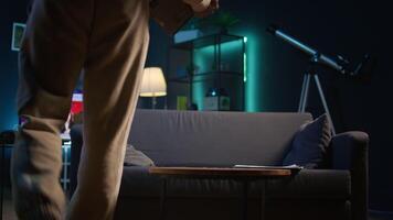 Ambitious black man learning a new language alone in his cozy living room, browsing internet for study platforms and explanations. Adult using language learning software online on laptop. Camera B. video
