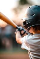 A young player focuses intently on swinging a baseball bat as teammates and fans cheer in the blurred background, capturing the lively atmosphere of the game at a local field photo